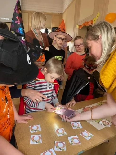 Zagadka z latarką – odgadywanie podświetlanego symbolu związanego z jesienią ukrytego w sylwetach dyń