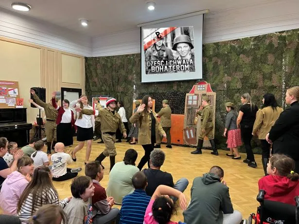 Zakończenie spotkania - wyjście uczniów z auli przy piosence „Warszawskie dzieci”.