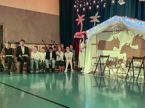 Babcia i dziadek opowiadaja wnukom historię o narodzinach Jezusa Chrustusa